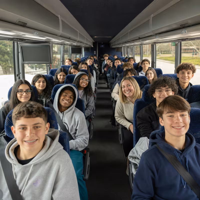 Group boarding a white charter bus for School Transportation transportation in Pasadena