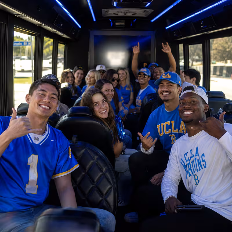 Group boarding a white charter bus for Sporting Event Transportation transportation in Pasadena